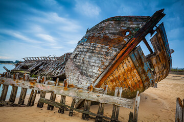 Old shipwrecks at the ship cemetary at river Etel in Brittany, France