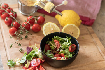 Preparación de ensalada de tomates y verdes, aceitando