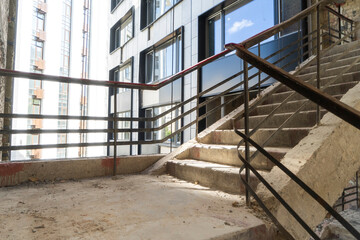 Empty building constrution with natural light. Unfinished staircase