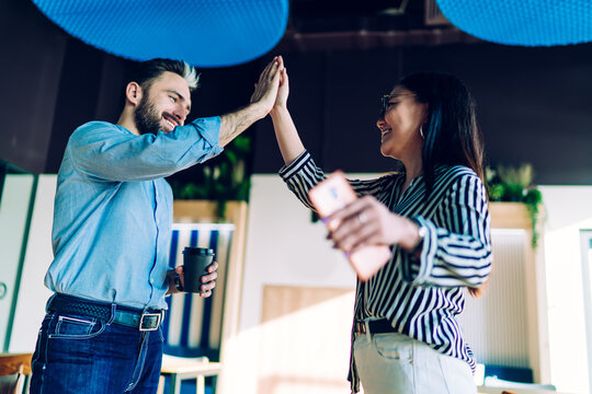 Satisfied partners doing high five in office