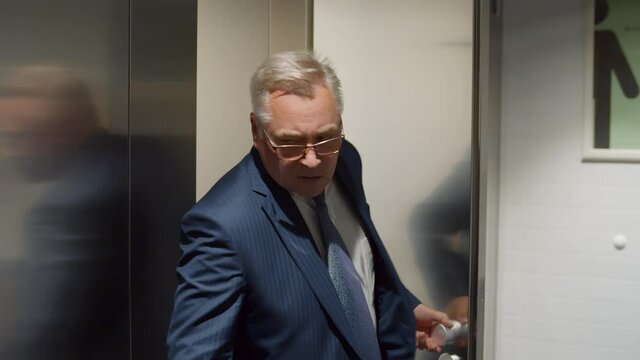 Business men entering and leaving toilet cabins on office restroom