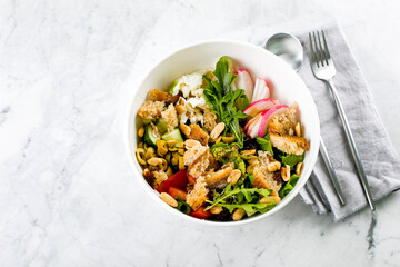 Healthy Salad Bowl. Mozzarella, vegetables, green leaves, green olives, whole grain bread, peanuts