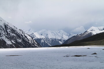A snowy mountain cover with clouds and land cover by snow a beautiful scenery 