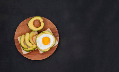 Healthy brekfast toasts with avocado on the black stone background flat lay mock-up with copy space