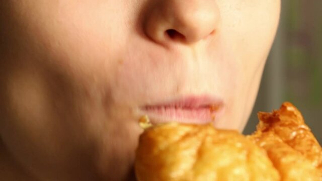 The girl eats a delicious delicious bun. Close-up, random shot.