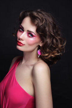 Portrait of young beautiful girl with curly hair and hot pink disco makeup