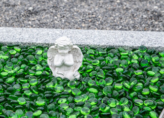 Betender Engel sitzt in grünem Glas