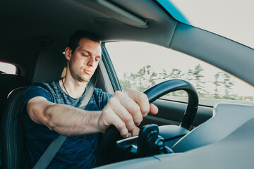 Tired driver falls asleep while driving car. Sleepy man wearing seat belt in vehicle. Risk of...