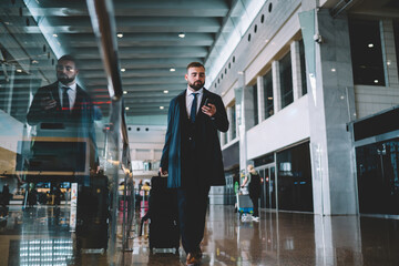 Confident bearded businessman walking in airport