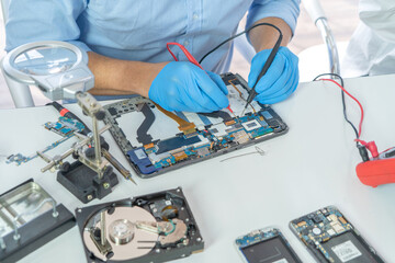 An engineer or technician western man working, examining or repairing computer motherboard...
