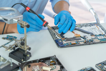 An engineer or technician western man working, examining or repairing computer motherboard...