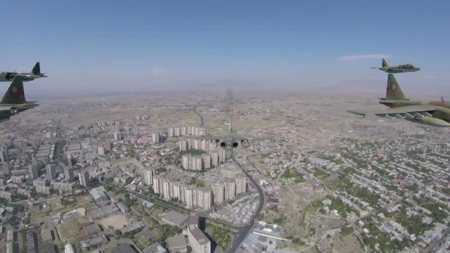 Six military attack aircrafts - fighters Su-25 of the Air Force Fly over the city and let out coloured smoke trails