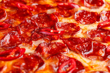 Pepperoni pizza on wooden board on dark background. Close-up