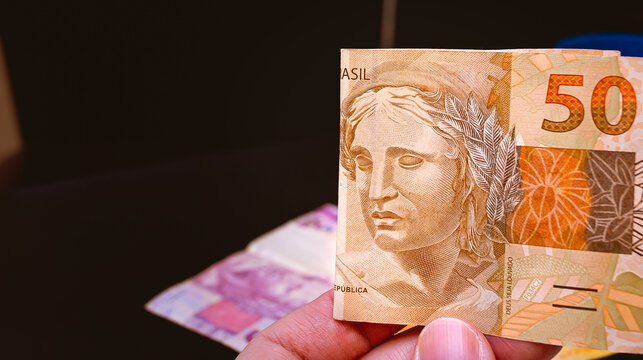 Real, Money from Brazil. Reais, Brazilian Real,  Currency, hand. A man holding a Real banknote.