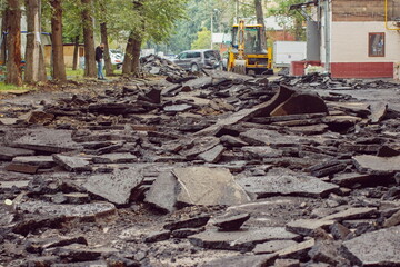 Pieces of broken asphalt with an excavator
