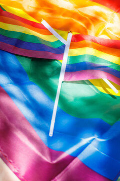 small LGBT flags against the background of a large banner of sexual minorities filling the picture, vertical photo