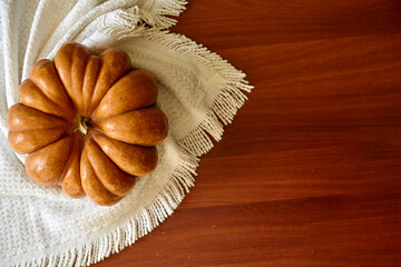 Autumn background with pumpkin on the white tablecloth. Cozy fall