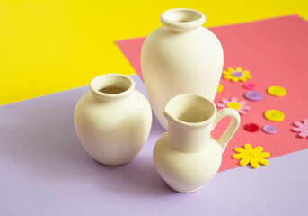 White clay vase on a bright colored background. Clay vessel for hand painting. Handmade.
