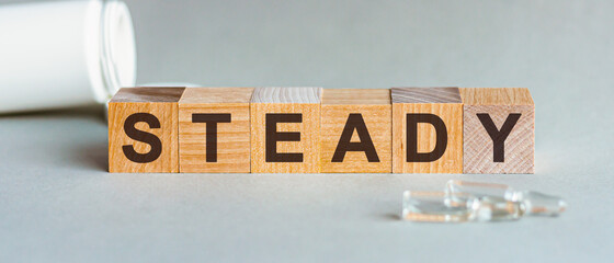 STABLE is a word written in black letters on wooden cubes.