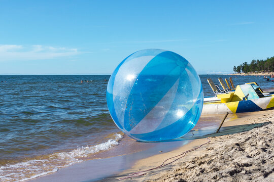 Empty zorb on the inshore waves, water activities, Zorbing extreme attraction for beach vacationers