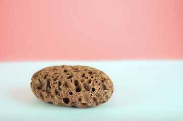 Pumice stone close up and copy space. Pumice stone 3d on a pink background. Beauty concept. Background for cosmetic product branding, identity and packaging inspiration. Podium with pink carnations an