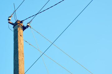 Power line post with electric cables against a clear sky. Power lines