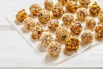 energy protein balls made with dry apricots, raisins, dates, walnuts, sunflower seeds, pumpkin seeds, sesame