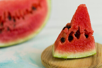a cut piece of watermelon on a wooden board