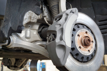 Brake caliper of a modern powerful car. The car has ventilated discs and a very large brake caliper. 