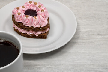 Heart shaped cake. Cake with a mug of coffee.