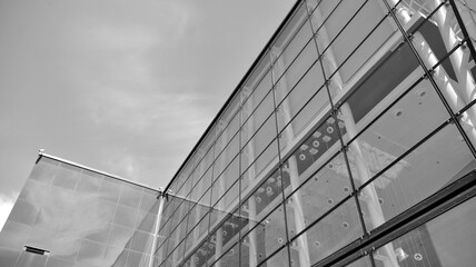Obraz premium Modern office building wall made of steel and glass with blue sky. Black and white.