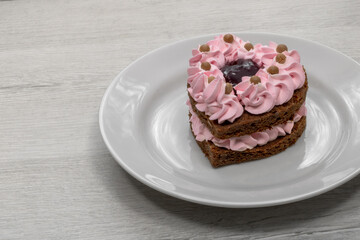 Heart-shaped cake. Cake on a white saucer.