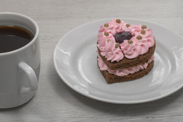 Heart shaped cake. Cake with a mug of coffee.