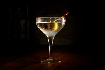 A classic vodka cocktail with a Martini and olives in a glass is on the bar