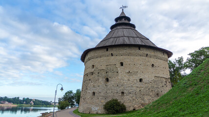 Pskov, Russia. Pokrovskaya fortress tower on the shore of the Velikaya river on a sunny day