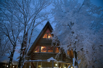 wooden cottage at night covered in snow, zakopane Poland  © Bonzales