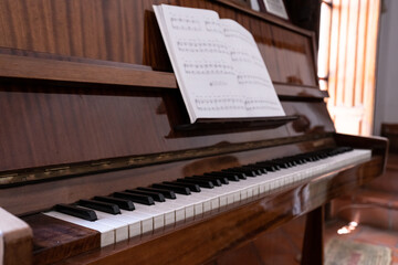 old piano color brown with musical book with black notes