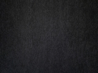 Black concrete wall is a decorative or textured surface. Can be used as a background or for design purposes
