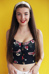 beautiful young brunette woman with long hair standing in a t-shirt and denim shorts
