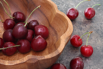 Red cherries in bowl on wooden background. Object, diet.