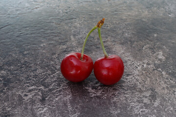Two cherries on a wooden background, place for text