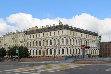 Fototapeta na wymiar Beautiful light yellow building in St. Petersburg and blue sky. Crossway. 