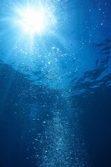 Air bubbles with sunshine underwater in the ocean, natural scene