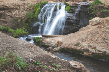 Obraz premium fresh water flows down dark rock to the Pacific Ocean at Alamere Falls in Point Reyes, California.