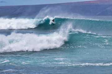 Unrecognizable surfer riding an enrgetic wave on Maui.