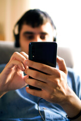 man sitting by the window listening to music