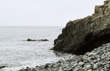 A Rocky Coastline with a Calm Sea on on Overcast Day