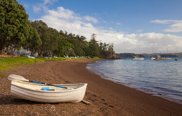 A dinghy rests on the shore in Russell, a seaside town in the Bay of Islands on the North Island of...
