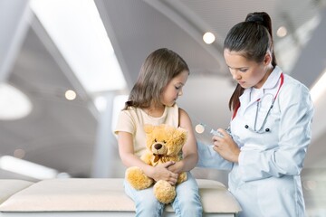 Doctor vaccinating little girl on hospital background