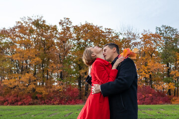 Passionate romantic young family hugging on the background of the autumn forest